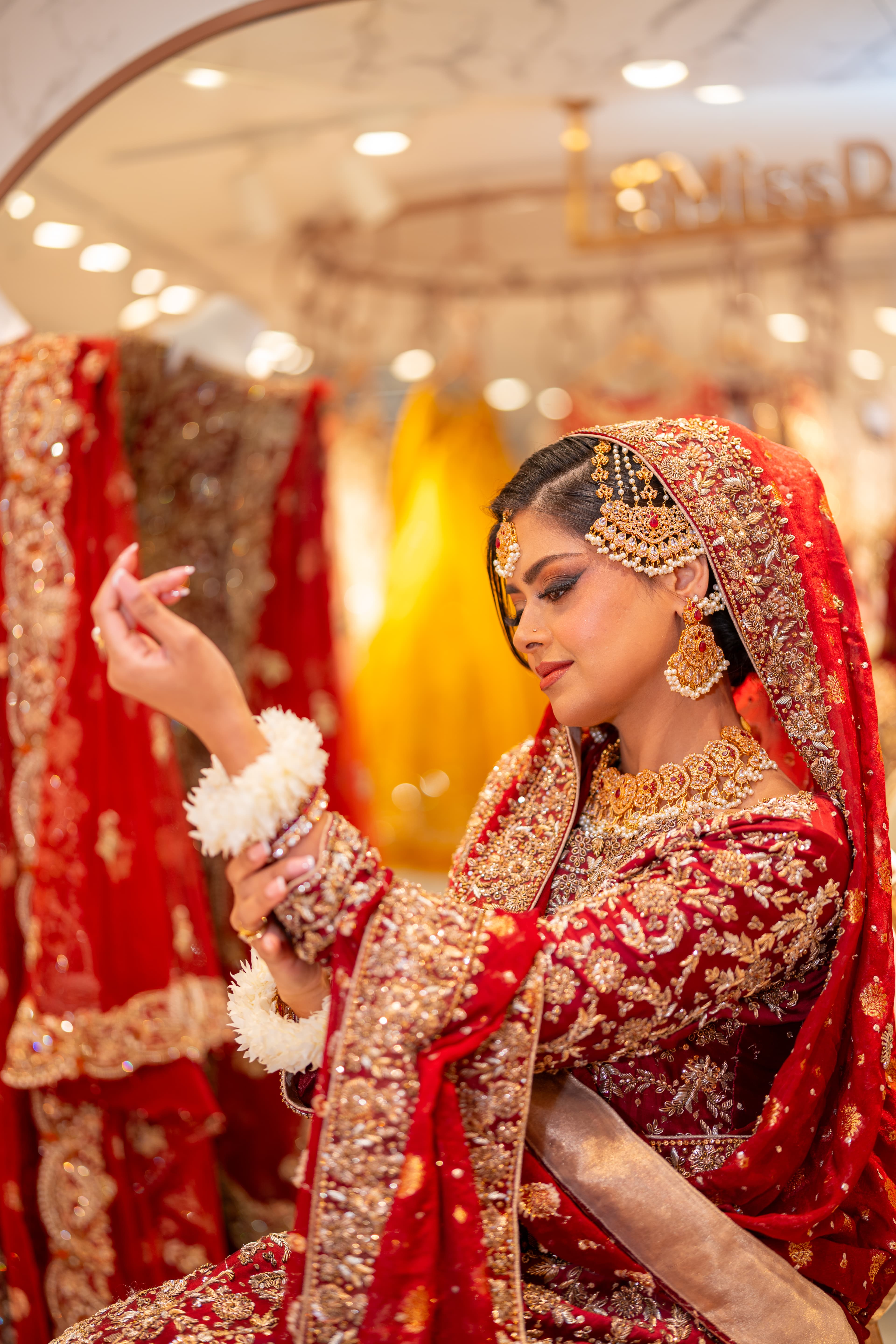 Bridal portrait in red and gold attire photographed with soft editorial light.
