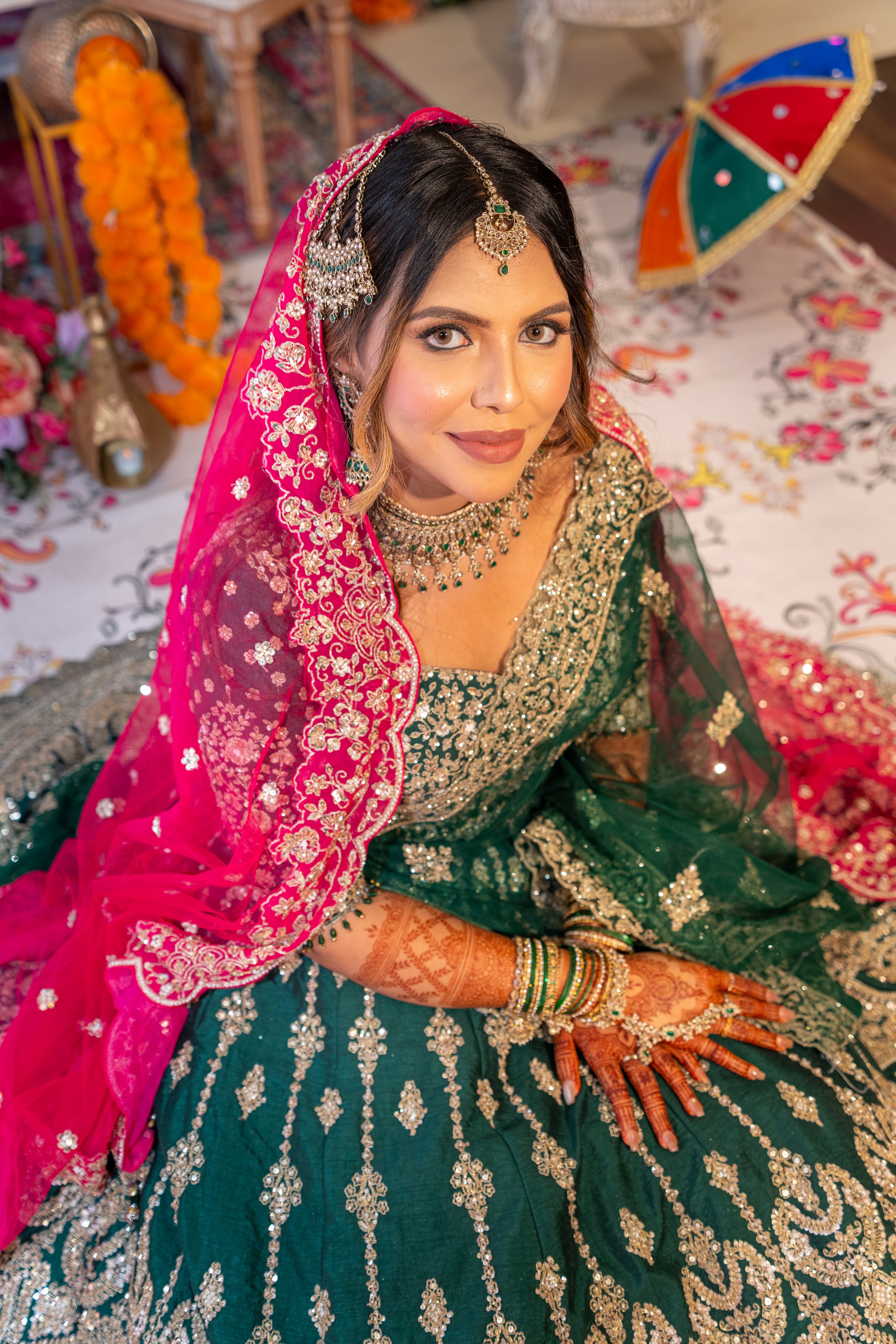 Close bridal portrait framed by vivid green and pink wedding decor.