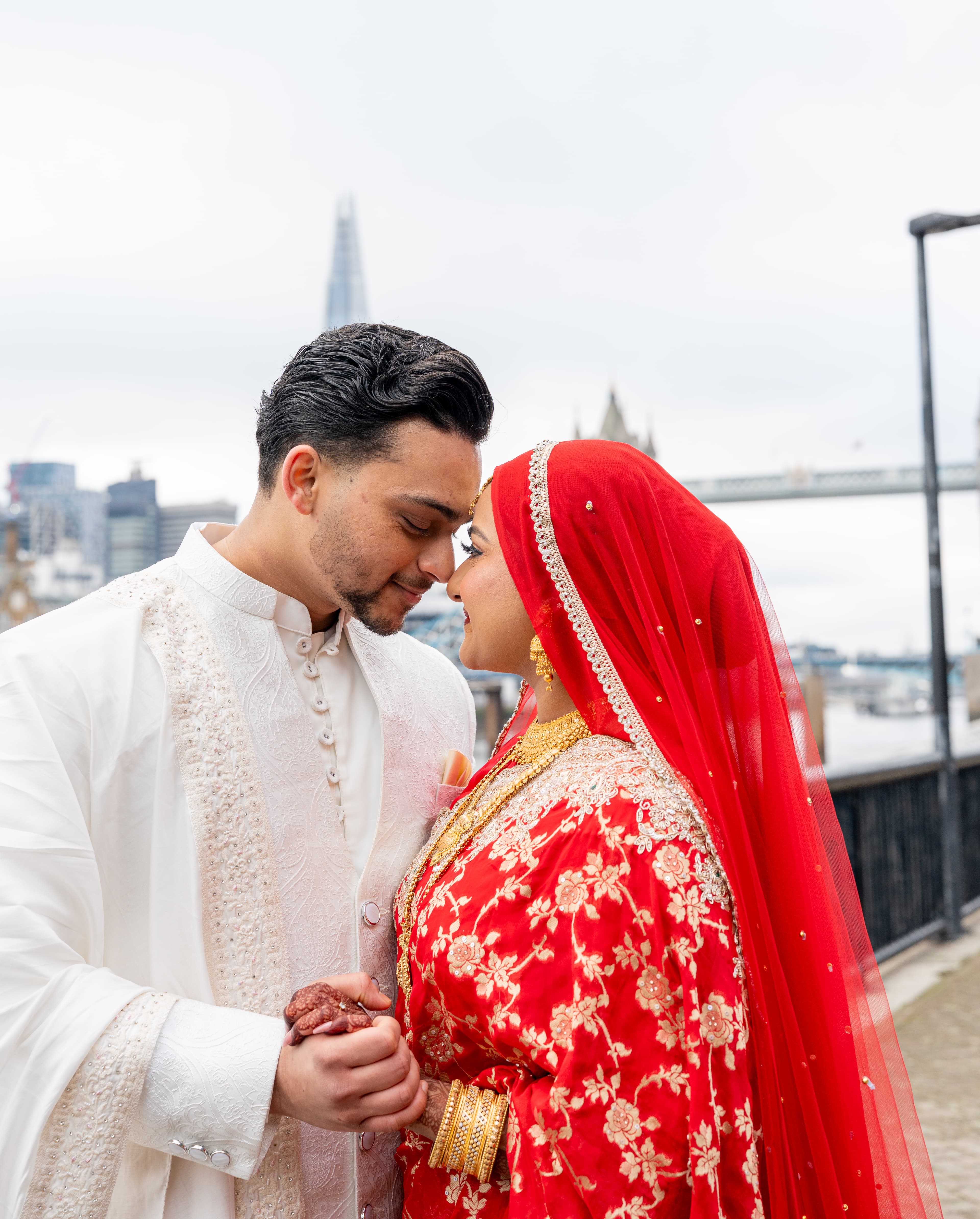 Couple standing closely together during an outdoor wedding portrait in London.